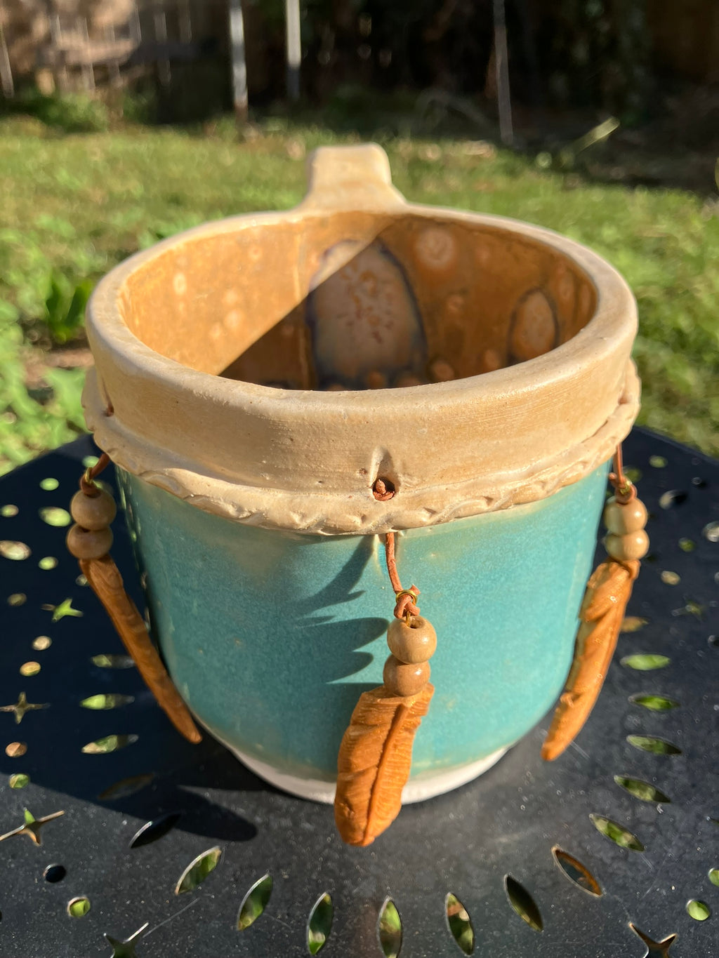 Handcrafted Dreamkeeper Mug with sculpted hanging feathers, turquoise glaze, and braided band detail, handmade pottery by Dhess Pottery