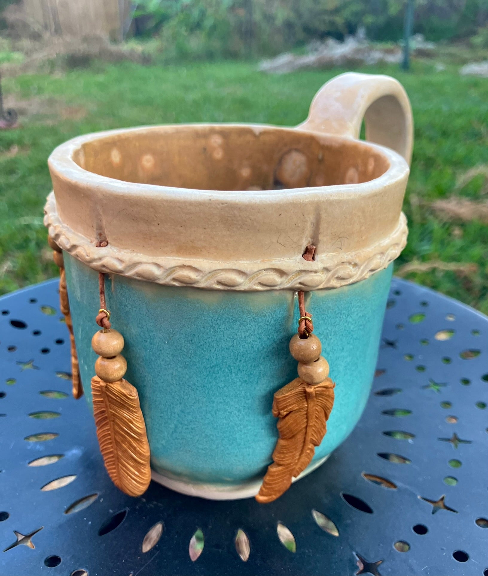 Handcrafted Dreamkeeper Mug with sculpted hanging feathers, Turquoise glaze, and braided band detail, handmade pottery by Dhess Pottery