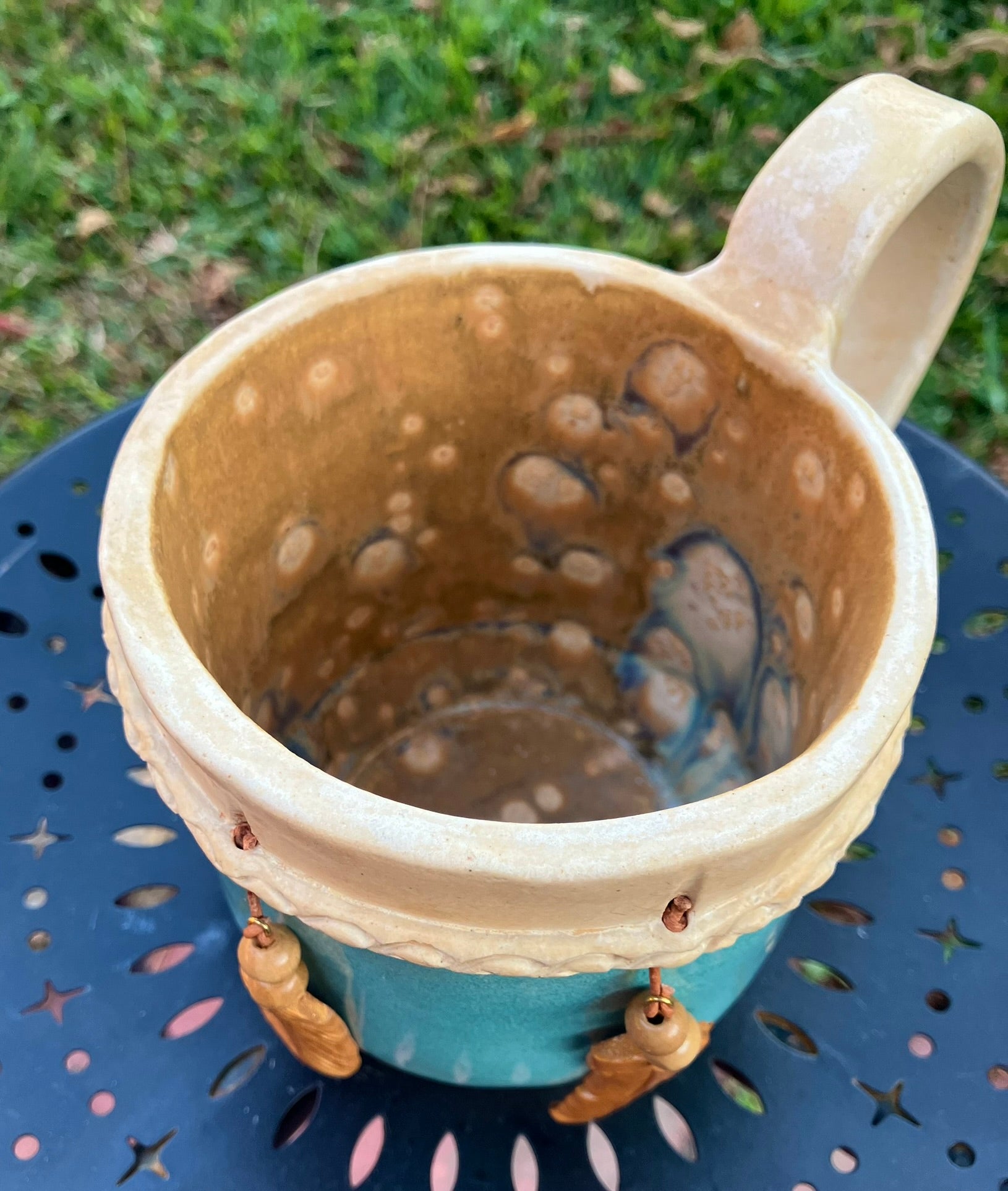 Handcrafted Dreamkeeper Mug with sculpted hanging feathers, Turquoise glaze, and braided band detail, handmade pottery by Dhess Pottery