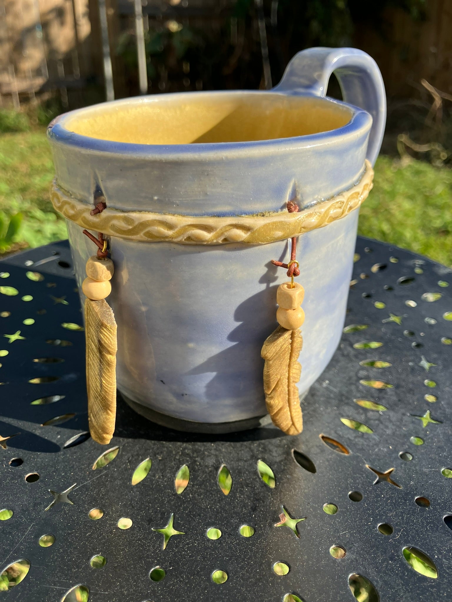 Handcrafted Dreamkeeper Mug with sculpted hanging feathers, blue sky glaze, and braided band detail, handmade pottery by Dhess Pottery