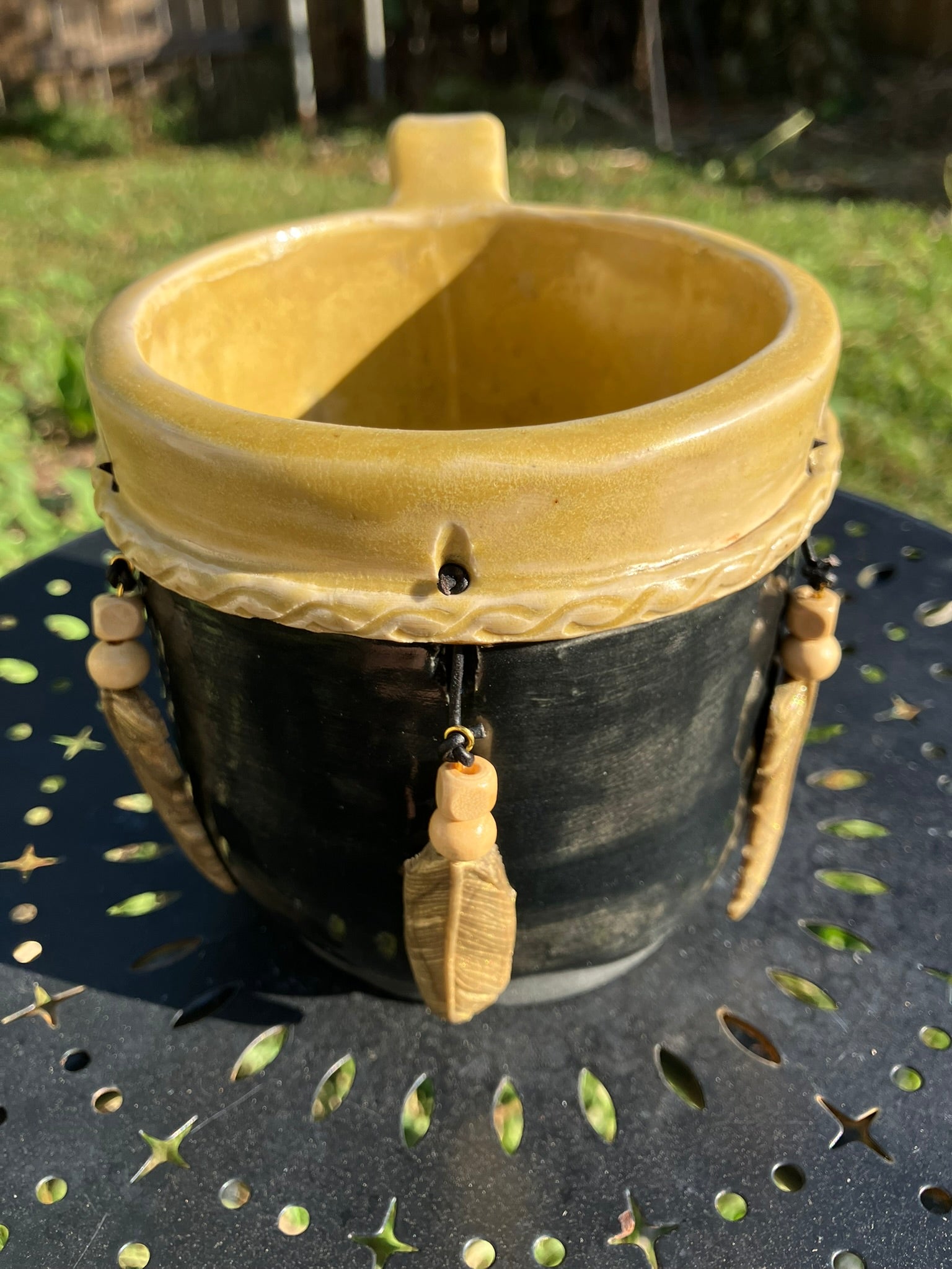 Handcrafted Dreamkeeper Mug with sculpted hanging feathers, Black & Gold glaze, and braided band detail, handmade pottery by Dhess Pottery