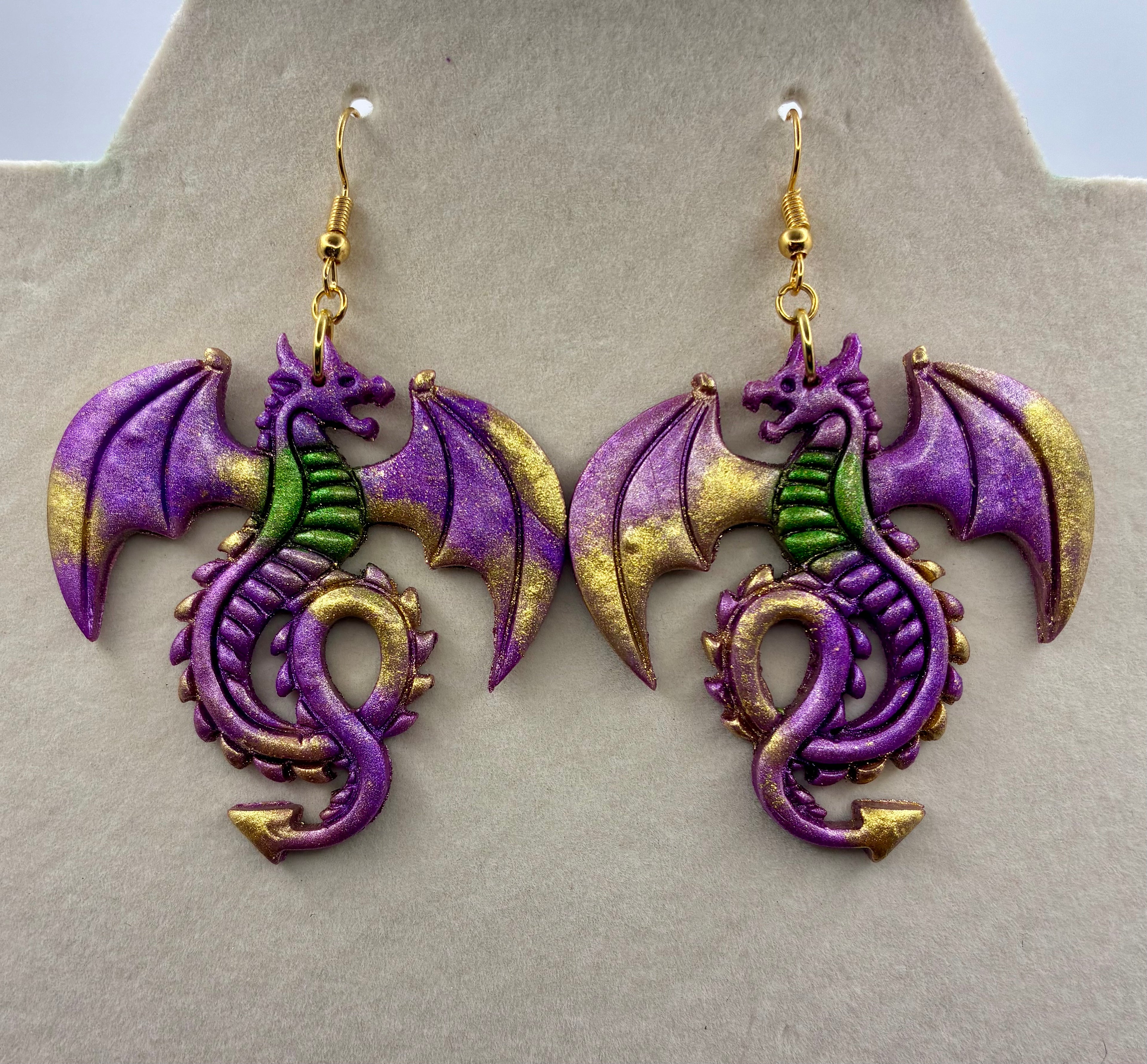 Dragon-shaped earrings on a gray display stand