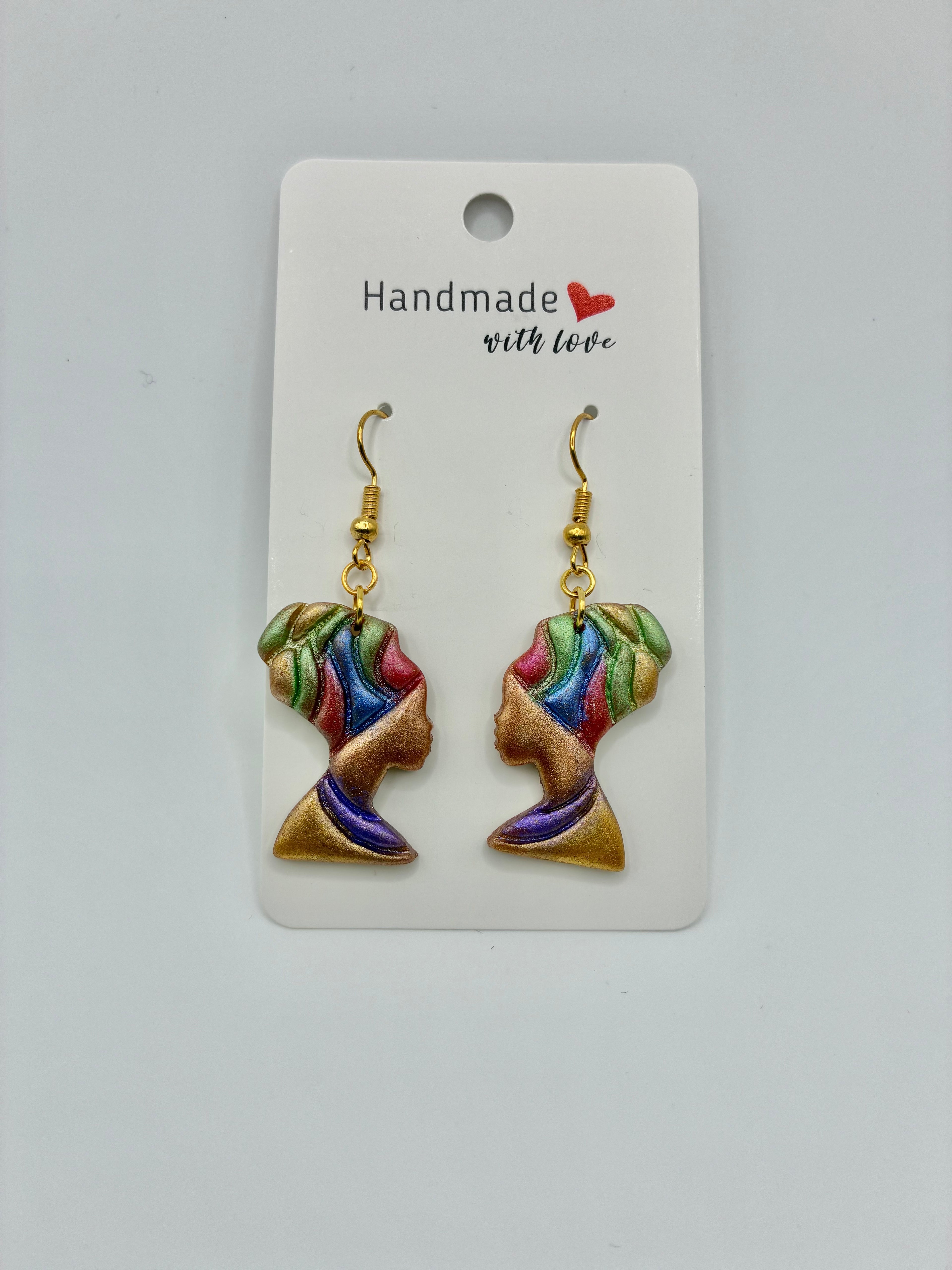 Earrings with colorful designs on a 'Handmade with Love' card against a white background