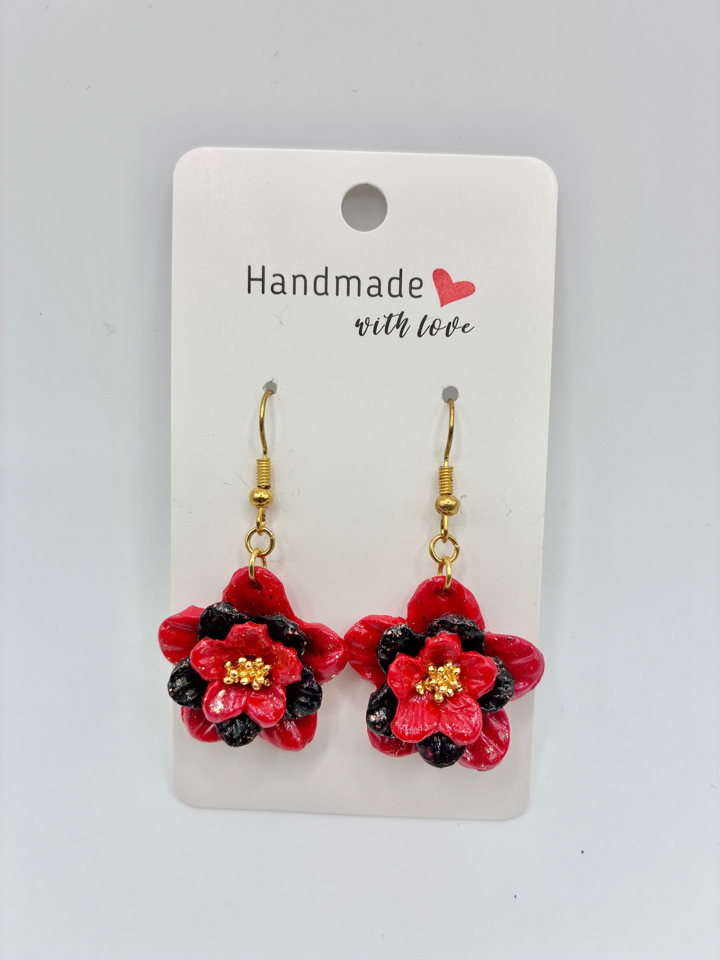 Red flower-shaped earrings on a 'Handmade with Love' card against a white background