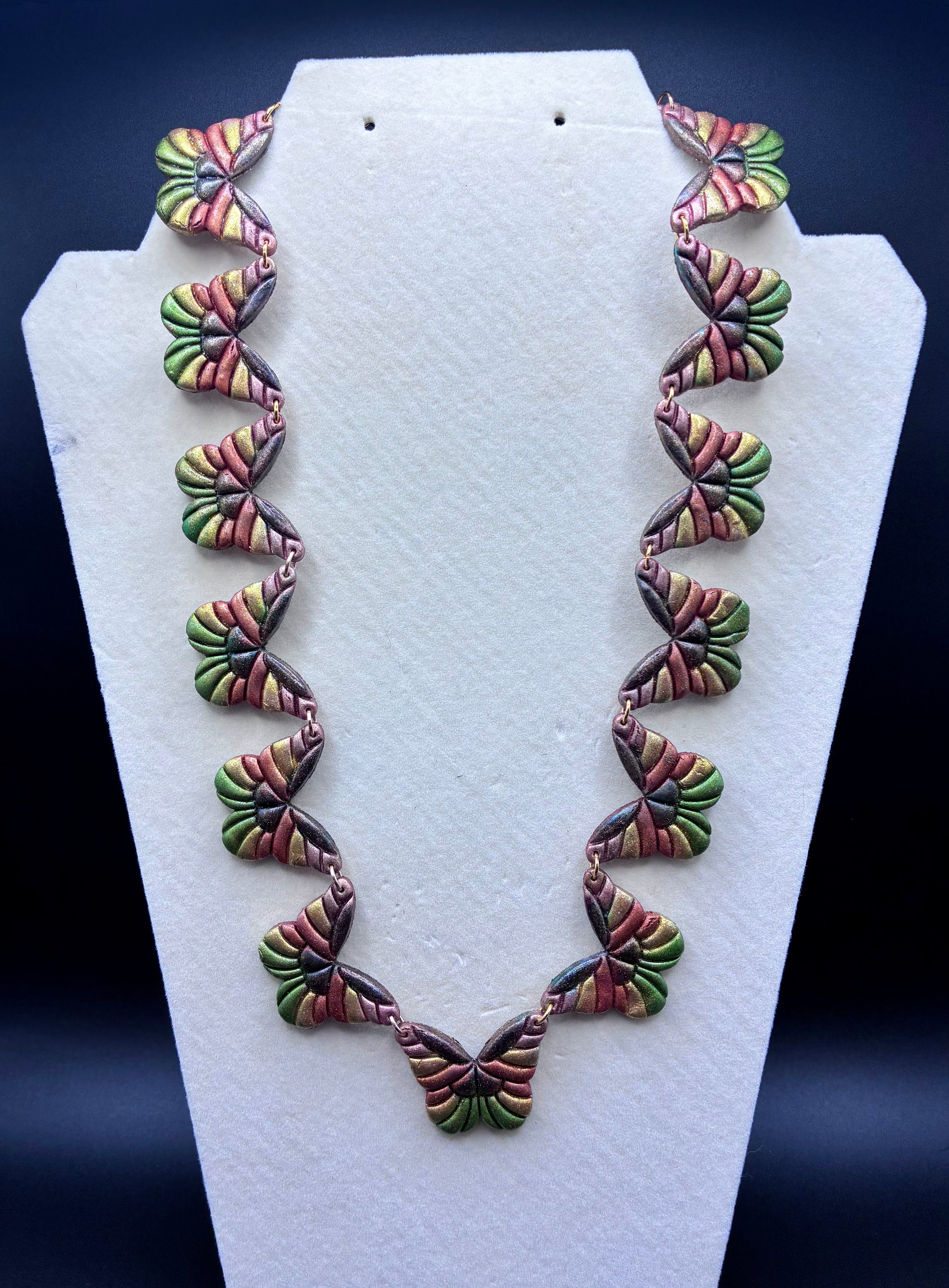 Colorful necklace on a white stand against a dark background